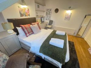 a bedroom with a large bed with a green blanket at Luxury Ensuite Rooms in Surbiton, An easy acess to central London in Surbiton