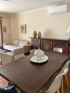 een woonkamer met een houten tafel en stoelen bij Jolie maison très calme in Ajaccio