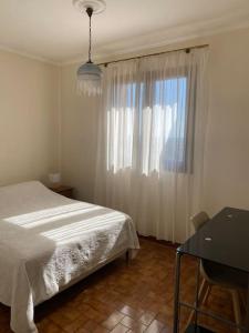 een slaapkamer met een bed, een bureau en een raam bij Jolie maison très calme in Ajaccio