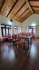 a dining room with a table and wooden chairs at Oak Essence in Mukteshwar