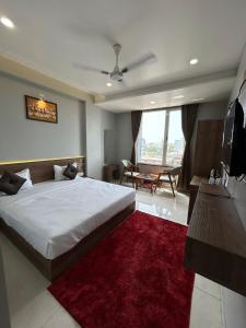 a bedroom with a large bed with a red rug at Hotel Holiday Icon in Dwarka