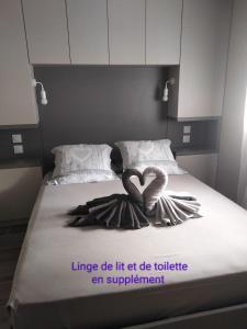 a bed with a heart shaped towel on it at Lou Mazet in Uchaud