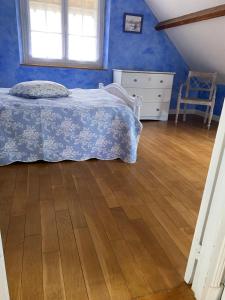 a bedroom with a bed and a wooden floor at Maison de Charme in Champs-Sur-Marne