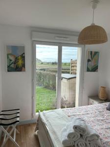 um quarto com uma cama e uma porta de vidro deslizante em Coquillages et crustacés em Criel-sur-Mer