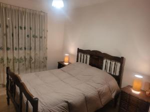 um quarto com uma cama e duas velas nas mesas em Alba alojamiento em Salta