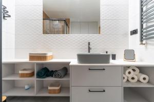 a bathroom with white cabinets and a sink at Apartament przy Baszcie - z prywatnym parkingiem w centrum - by SpaceApart in Jelenia Góra