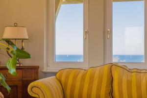 salon z żółtą kanapą i dwoma oknami w obiekcie Villa Modiva w mieście Międzyzdroje