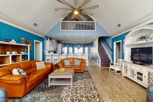a living room with orange furniture and blue walls at Shore Beats Work in Dauphin Island