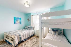 a bedroom with two bunk beds and a window at Shore Beats Work in Dauphin Island
