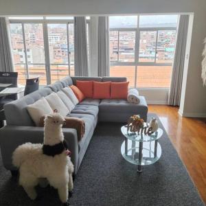 un perro parado en una sala de estar con sofá en Elite Apartment 2 en Cuzco