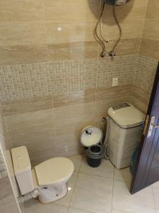 a bathroom with a toilet and a trash can at Lasirena mini egypt in Ain Sokhna