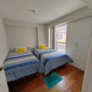 2 camas en una habitación con ventana en Elite Apartment 2 en Cuzco