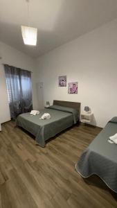 - une chambre avec 2 lits et du parquet dans l'établissement Carpentry, à Uggiano la Chiesa
