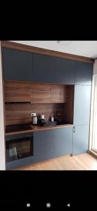 cocina con armarios de madera y fogones en Apartman I&N, en Zlatibor