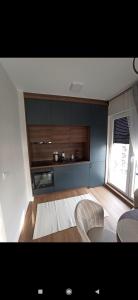 Una sala de estar con un sofá y una cocina. en Apartman I&N, en Zlatibor