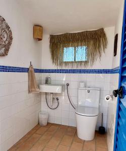 uma casa de banho com um WC e um lavatório em Bohovilla mit Meerblick und Pool - Casa da Primavera em Mato Porcas
