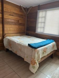 Cama pequeña en habitación con paredes de madera en Casa aconchegante, en São Francisco do Sul