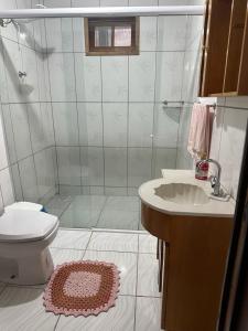 y baño con ducha, aseo y lavamanos. en Casa aconchegante, en São Francisco do Sul
