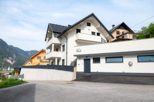 a white house with a black roof at Apartments Luxury AD in Jesenice