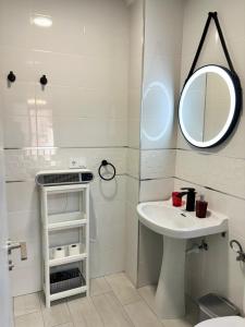 a bathroom with a sink and a mirror at Apartamento Sofía I a 500m de la Playa con Parking solo para motos y bicicletas in Puerto de Sagunto