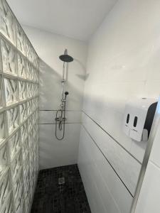 a white bathroom with a shower and a soap dispenser at Apartamento Sofía I a 500m de la Playa con Parking solo para motos y bicicletas in Puerto de Sagunto