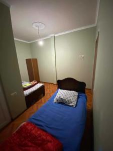 a bedroom with a blue bed in a room at Guest House Gela in Batumi