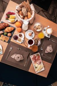 - une table avec des aliments pour le petit-déjeuner et du café dans l'établissement Hotel Goldene Rose, à Monguelfo-Tesid