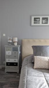 - une chambre avec un lit et une table de chevet avec une lampe dans l'établissement Opale Baie, à Berck-sur-Mer