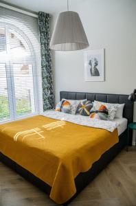 a bedroom with a bed with a yellow blanket at Brokilon House in Krakow