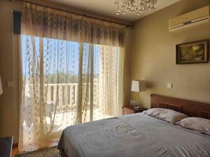 een slaapkamer met een bed en een groot raam bij Budget Escape to the seaside in Larnaka