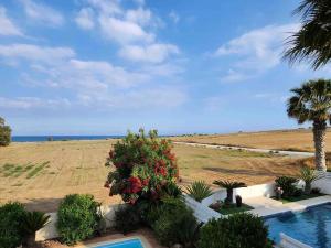 een villa met een zwembad en uitzicht op de oceaan bij Budget Escape to the seaside in Larnaka