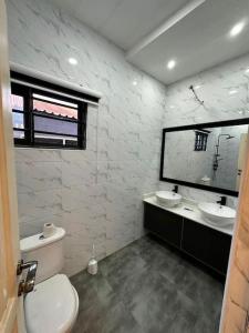 a bathroom with two sinks and a toilet and a mirror at Fully Furnished 1 Bedroom House in Accra