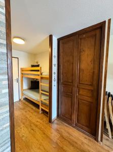 a room with a door and a bunk bed at 4- Joli studio Brides-les-Bains avec vue montagne in Brides-les-Bains