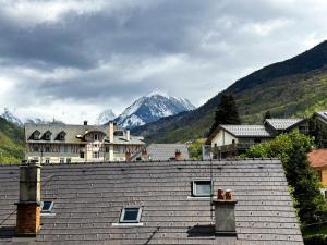 a house on top of a roof with mountains in the background at 4- Joli studio Brides-les-Bains avec vue montagne in Brides-les-Bains