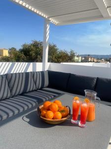 un tazón de naranjas y dos vasos de zumo de naranja en Villa Playa de Turmalina - Denia El Verger, en El Verger