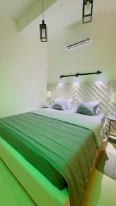 a bedroom with a large bed with green sheets at Holiday Homes Guest Inn - Ella in Ella