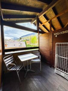 Zimmer mit einem Tisch, 2 Stühlen und einem Fenster in der Unterkunft 4- Joli studio Brides-les-Bains avec vue montagne in Brides-les-Bains