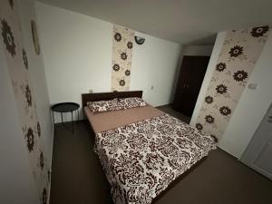 a bedroom with a bed with a black and white comforter at Camere de Închiriat David Corbu in Corbu +8 photos