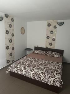 a bedroom with a bed with a black and white comforter at Camere de Închiriat David Corbu in Corbu