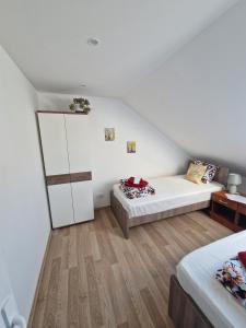 a attic bedroom with two beds and a closet at Apartman Viking in Donji Milanovac