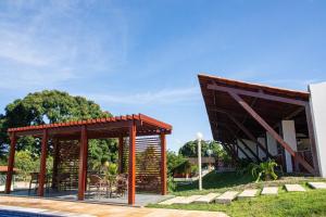 een paviljoen met tafels en stoelen naast een zwembad bij CAMARATUBA HOTEL FAZENDA in Mamanguape