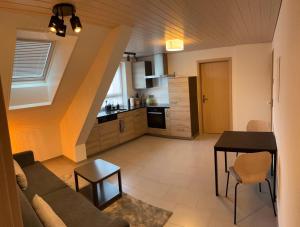 a living room and kitchen with a couch and a table at Cozy appartement de vacances "La Poste" in Saignelégier