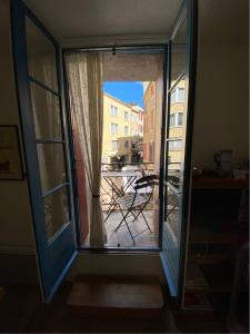 an open door to a balcony with a table outside at Aux 4 FONTAINES in Narbonne