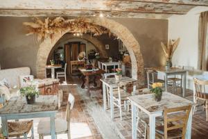 una sala da pranzo con tavoli, sedie e arco di Locanda in Tuscany a Castiglione dʼOrcia