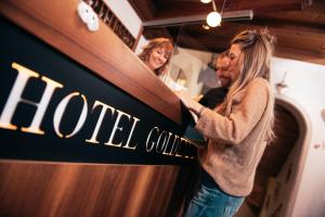 Una donna sta in piedi davanti a uno specchio di Hotel Goldene Rose a Monguelfo