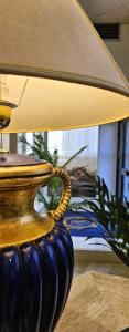 a blue vase sitting on a table with a lamp at Hotel Palace Masoanri's in Reggio di Calabria