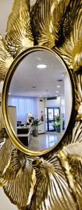a mirror with a reflection of a living room at Hotel Palace Masoanri's in Reggio di Calabria