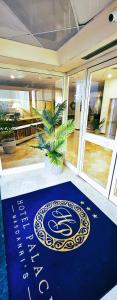 a blue welcome mat in a room with a house at Hotel Palace Masoanri's in Reggio di Calabria