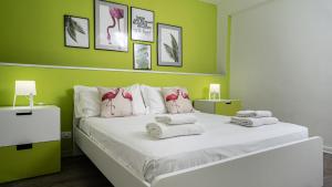 een groene slaapkamer met een bed met handdoeken erop bij Casamemi San Lorenzo a due passi dalla Spiaggia in Reitani