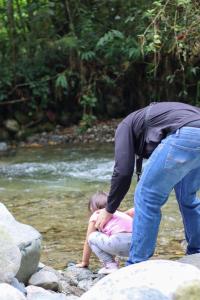 a man and a little girl playing in the water at Curigua Ecolodge-Sendero Cascada la milagrosa Buga in La Primavera